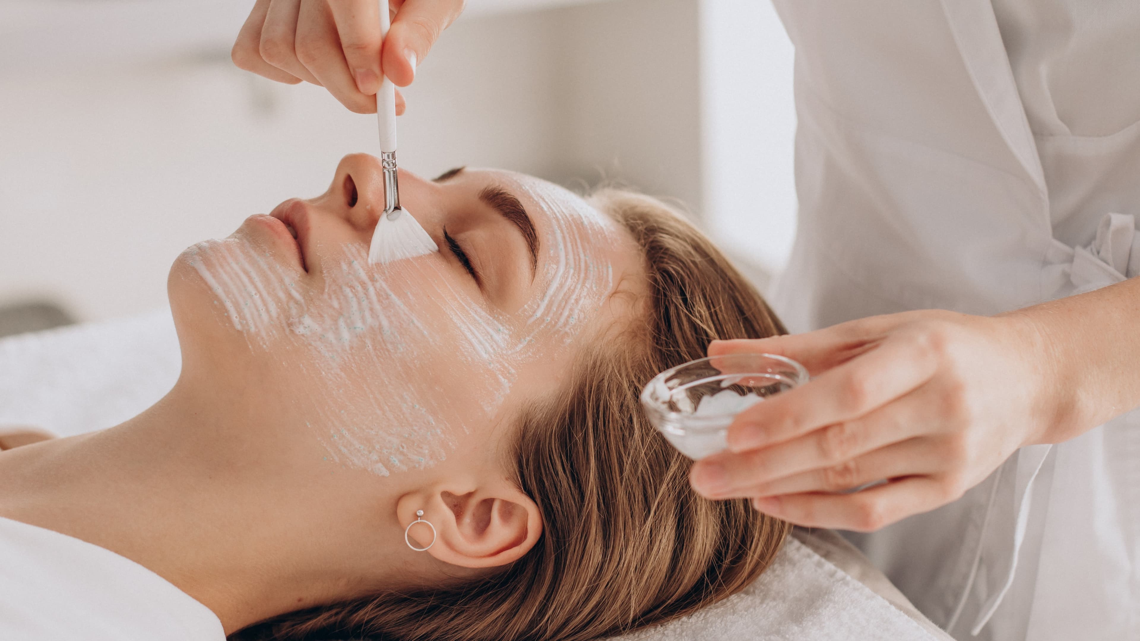 cosmetologist-doing-face-treatment-and-applying-face-mask